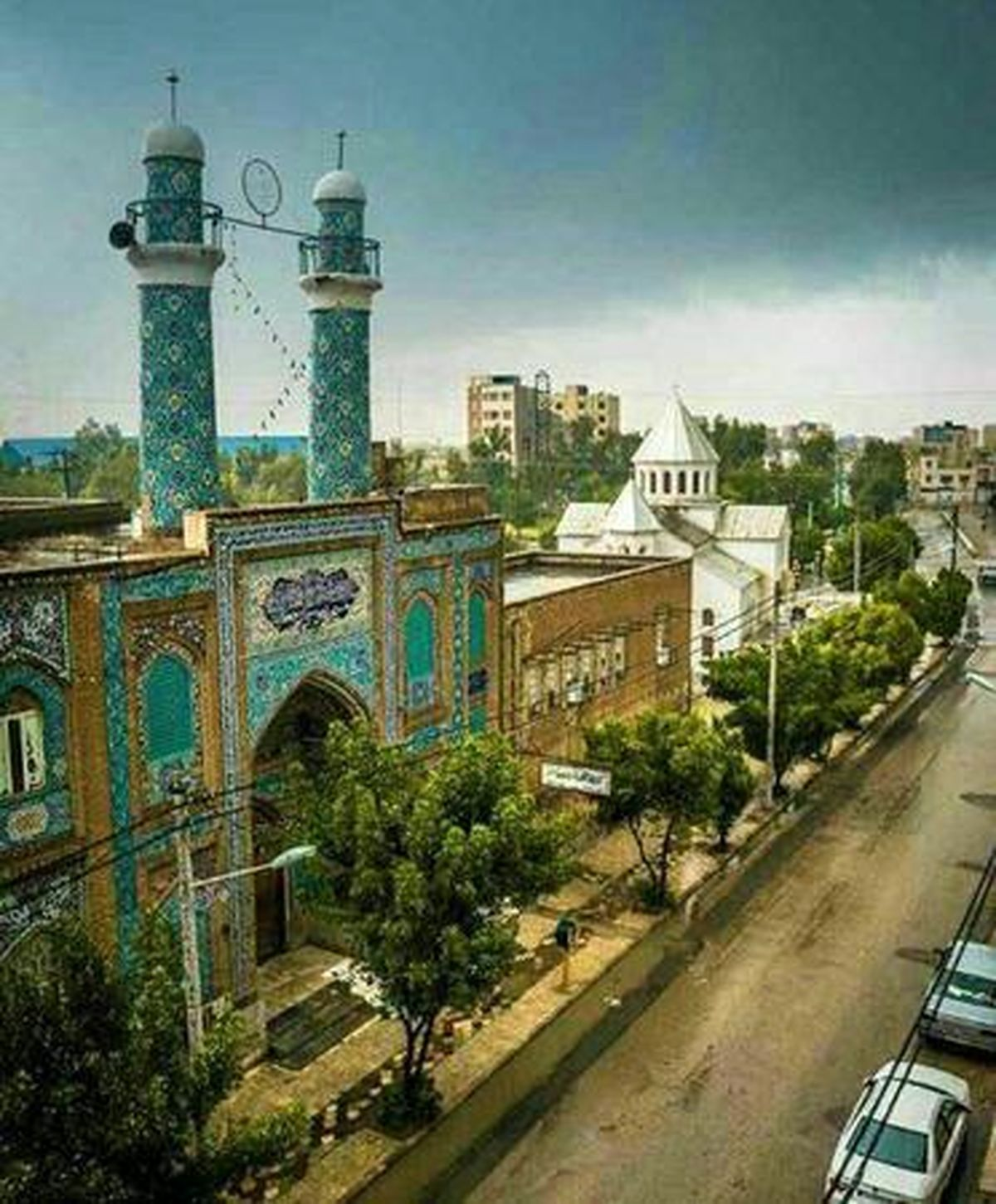 A church next to a mosque in Iran. They even share the same side wall!